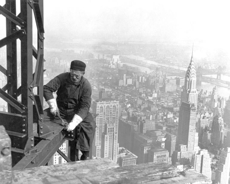 Construction worker bolting the steel framework of the Empire State Building in New York City, 1930.