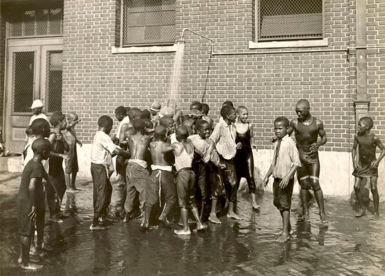 Children gather at the outdoor public shower at School No. 101, the Paul Laurence Dunbar School, an African American school within Baltimore’s segregated school system, August 1924.